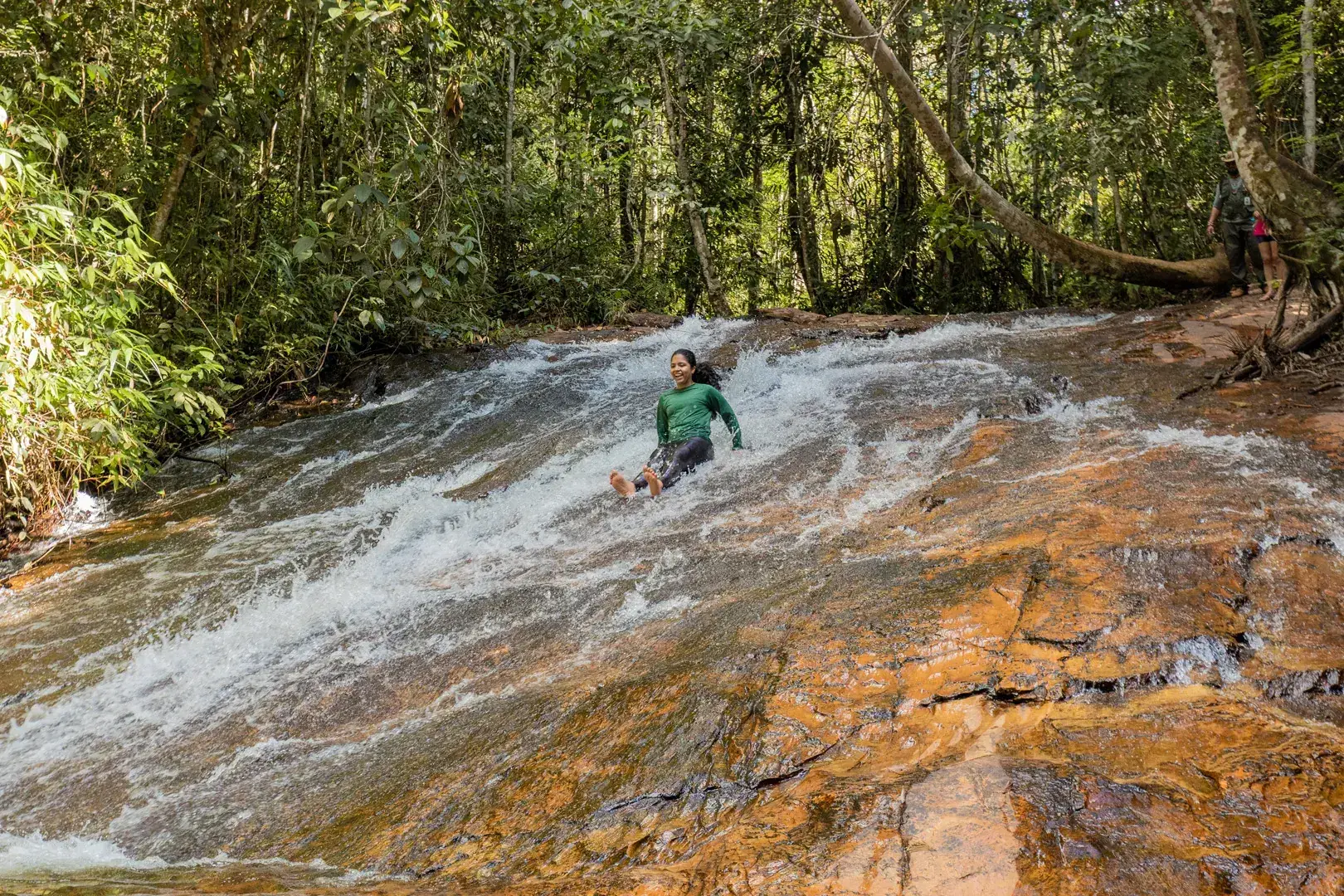 Visitante deslizando na laje da Cachoeira de Águas Claras